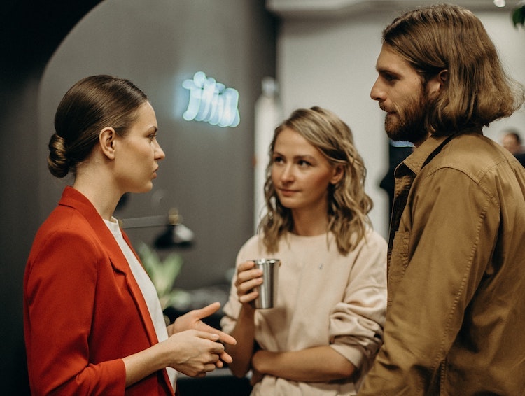 Two women and one man in the workspace deep in conversation