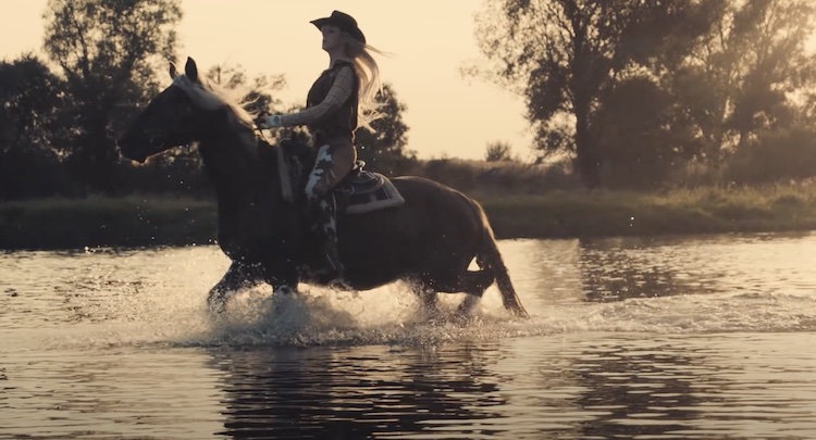Woman on horseback in river 