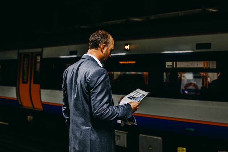 Man reads paper at Underground station