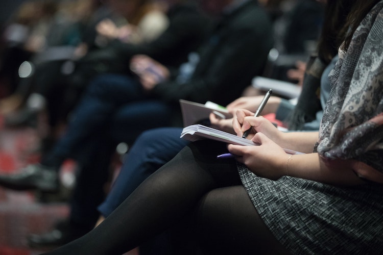 Woman's hands takes notes at conference