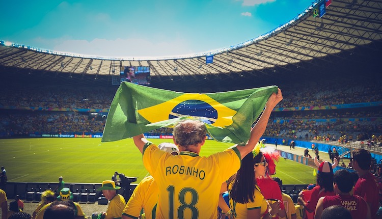 Brazilian football fan in stadium waves flag