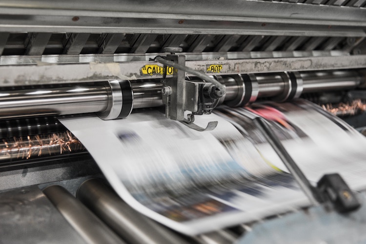 Newspaper being printed on printing press