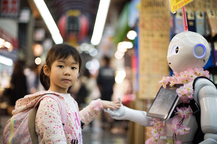 asian girl holds hands with robot