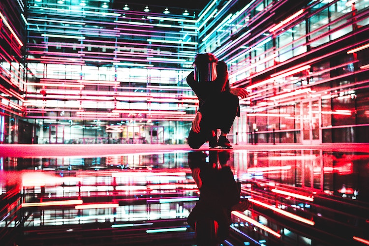 crouching person surrounded by horizontal lights