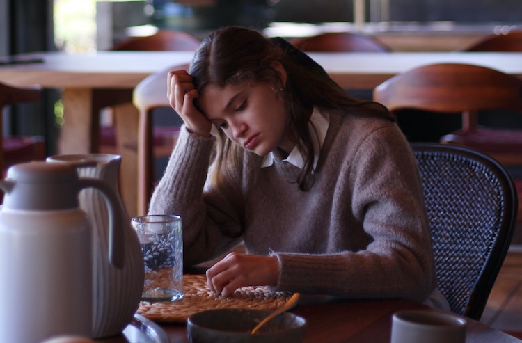 woman looks sad in coffee shop