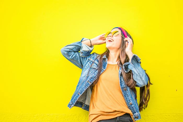 Happy young woman on bright yellow background